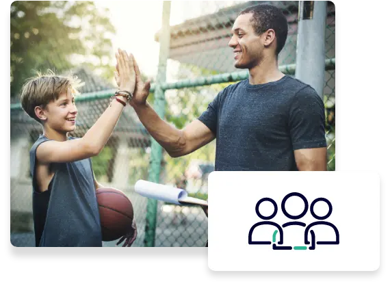 A boy carrying a basketball gives his mentor a high five.