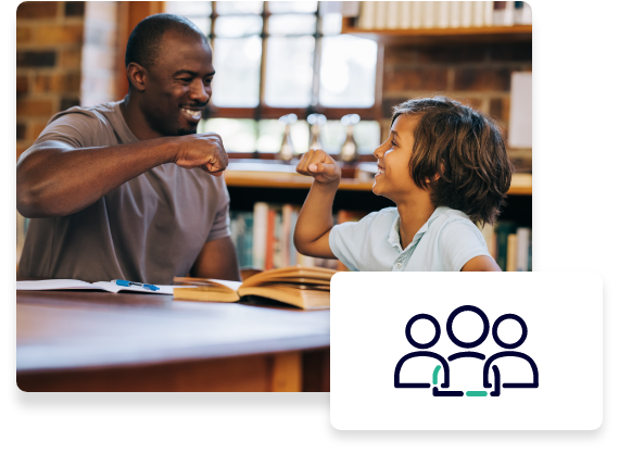 A child reading a book smiles and fist bumps their mentor.