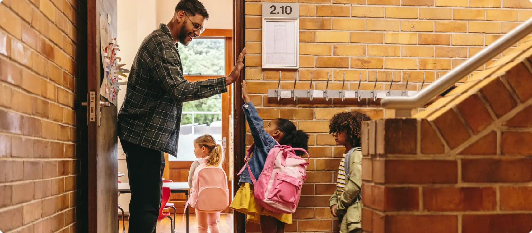 A woman smiles and leans against a glass door frame.