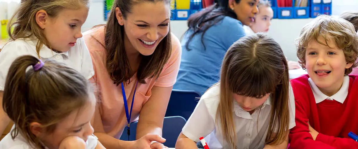 Daycare provider draws pictures with kids.